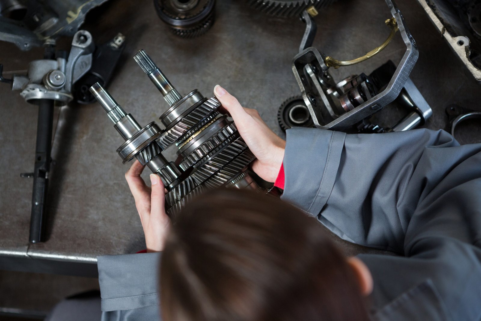 Female mechanic holding spare parts at repair garage